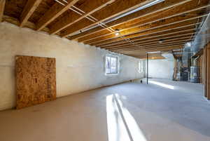 Basement featuring heating unit and secured water heater