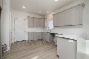 Kitchen with light hardwood / wood-style flooring, sink, and gray cabinets