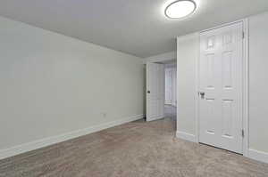 Unfurnished bedroom with a textured ceiling and light carpet