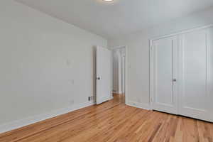 Unfurnished bedroom with light wood-type flooring and a closet