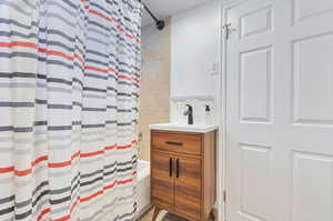 Bathroom with vanity and shower / bath combo with shower curtain