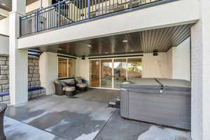 View of patio with a balcony and a hot tub