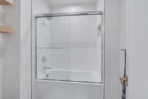 Bathroom featuring shower / bath combination with glass door