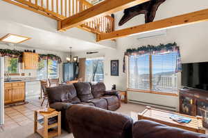 Living room with a baseboard heating unit, and light tile and carpet patterned floors