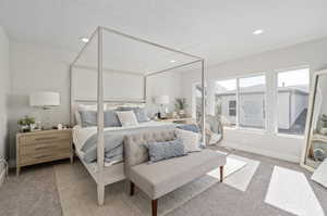 Bedroom with light colored carpet and a textured ceiling