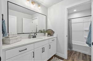 Bathroom with shower / tub combo, vanity, and wood-type flooring