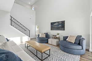 Living room with hardwood / wood-style flooring and a high ceiling