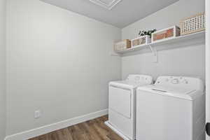 Clothes washing area with dark wood-type flooring, a textured ceiling, and washer and clothes dryer