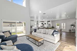 Living room with light hardwood / wood-style floors and a high ceiling