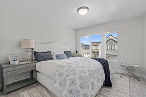 Bedroom with light colored carpet and a textured ceiling