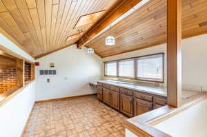 Kitchen with wood ceiling, hanging light fixtures, and lofted ceiling with skylight