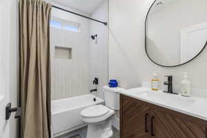 Full main floor bathroom with tile patterned floors, vanity,  full tile shower / bath combination