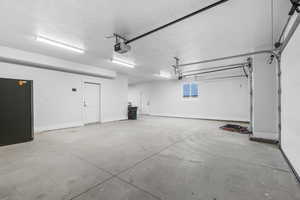 3 car garage featuring dual garage door openers and worshop/storage area