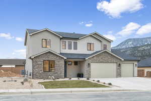 View of front of house featuring a mountain view, a 3-car garage, and heat-pump/central AC