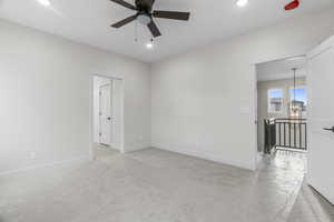 Primary bedroom featuring ensuite bath, ceiling fan, and light carpet