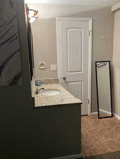 Sink in bedroom featuring vanity and tile patterned flooring