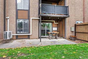 Rear view of house with a yard, a  covered patio area, and ac unit