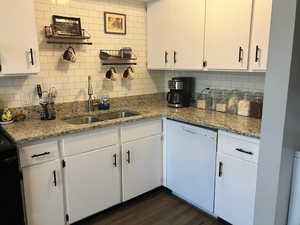 Kitchen featuring tasteful backsplash, white cabinets, sink, dark hardwood / wood-style flooring, and dishwasher