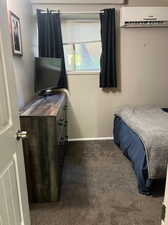 Bedroom featuring carpet floors and a wall unit AC