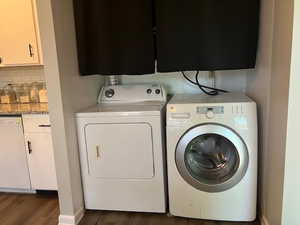 In kitchen Laundry area with independent washer and dryer and dark hardwood / wood-style flooring