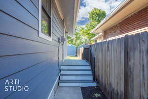 View Of East Side Of The Home Featuring NEW Trex Deck & Black Railing.  NEW Siding, Gutters, Soffit & Fascia. This Side Features Your Side Entry Door & Access To The Large Fenced In Backyard w/Parking Pad & Shed.