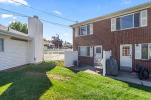 Back of property featuring a yard, cooling unit, and a patio