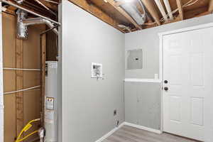 Laundry area with electric panel, hookup for a washing machine, water heater, hardwood / wood-style floors, and electric dryer hookup