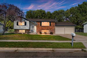 Split foyer home with a lawn and a garage