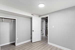 Unfurnished bedroom with light wood-type flooring and a closet