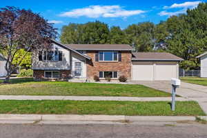 Bi-level home featuring a front yard and a garage