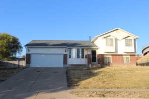 Split level home with a garage and a front lawn