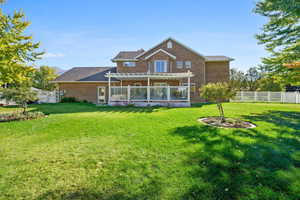 Rear view of property with a yard and a pergola