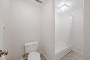 Basement Bathroom with toilet and shower / bathtub.