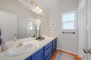 Bathroom featuring vanity, lofted ceiling, and hardwood / wood-style floors