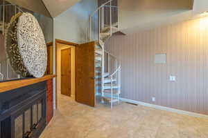 Living room with a fireplace, wood walls, and high vaulted ceiling