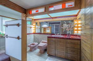 Bathroom with toilet, an enclosed shower, vanity, and a bidet