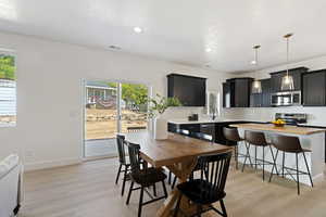 Dining space with plenty of natural light, sink, and light wood-type flooring