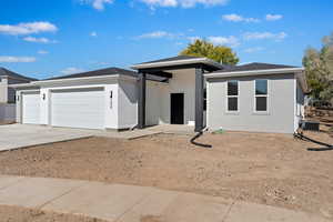 View of front of home featuring central AC unit and a garage