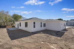 Back of property with a mountain view and a patio area