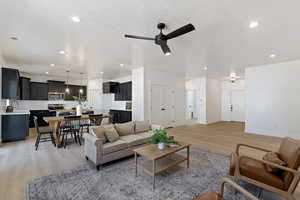 Living room featuring ceiling fan, a textured ceiling, sink, and light hardwood / wood-style floors