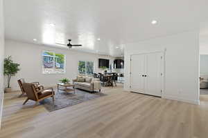 Living room with ceiling fan and light wood-type flooring