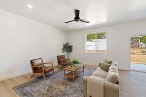 Living room with ceiling fan, hardwood / wood-style flooring, a wealth of natural light, and a textured ceiling