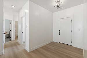 Entryway with an inviting chandelier and light hardwood / wood-style flooring