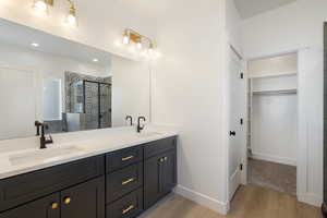 Bathroom featuring vanity, a shower with door, and hardwood / wood-style flooring