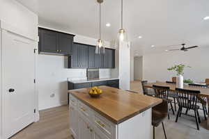 Kitchen featuring pendant lighting, a kitchen island, gray cabinetry, and light wood-type flooring