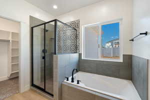 Bathroom featuring shower with separate bathtub and hardwood / wood-style floors