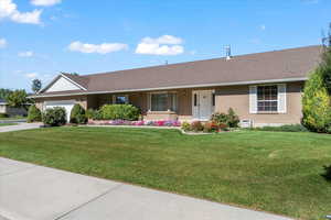 Single story home featuring a front yard and a garage