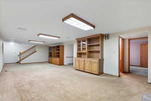 Unfurnished living room featuring light carpet