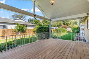 Covered Trex deck with a beautifully landscaped backyard