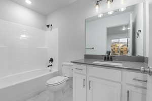 Full bathroom with shower / tub combination, vanity, and toilet